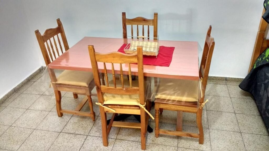 Comedor con mesa y sillas de madera en un departamento de alquiler temporario en Villa Carlos Paz