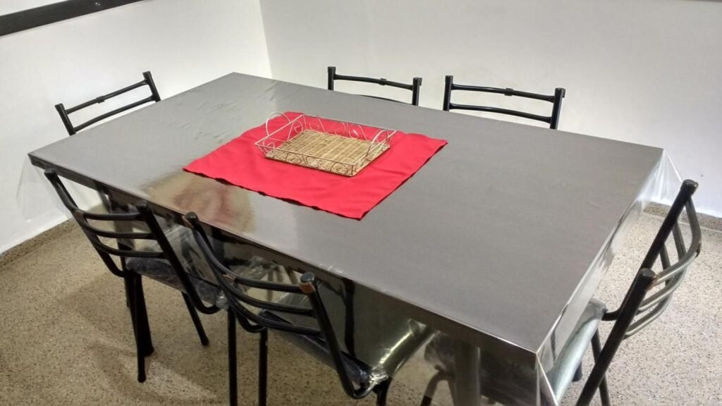 Comedor con mesa para seis y TV, en un departamento de dos habitaciones en Villa Carlos Paz
